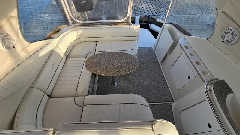 Slide: The Image of 1999 Maxum 3000 SCR boat interior with white leather seating and round table. - 12