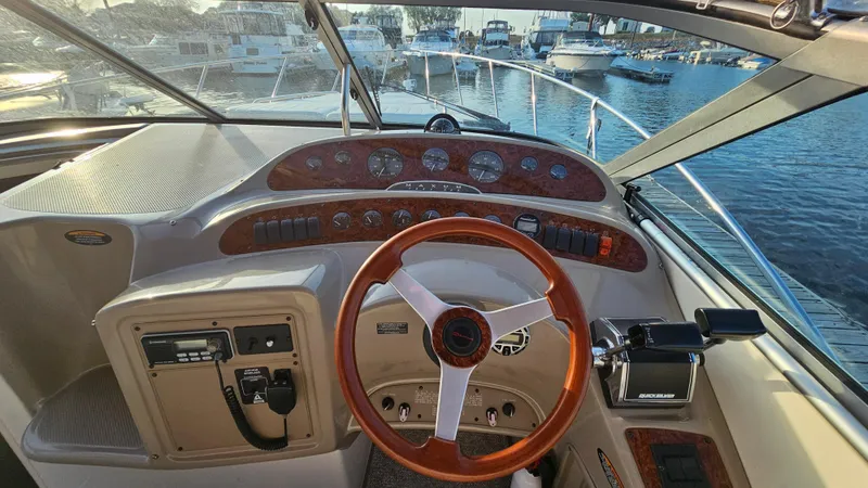 Slide: The Image of 1999 Maxum 3000 SCR boat helm with wooden steering wheel and control panel. - 14