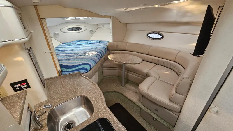 Slide: The Image of 1999 Maxum 3000 SCR interior with kitchenette, seating area, and bed. - 16