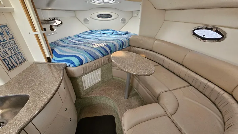 Slide: The Image of 1999 Maxum 3000 SCR cabin interior with bed, kitchenette, and seating area. - 17