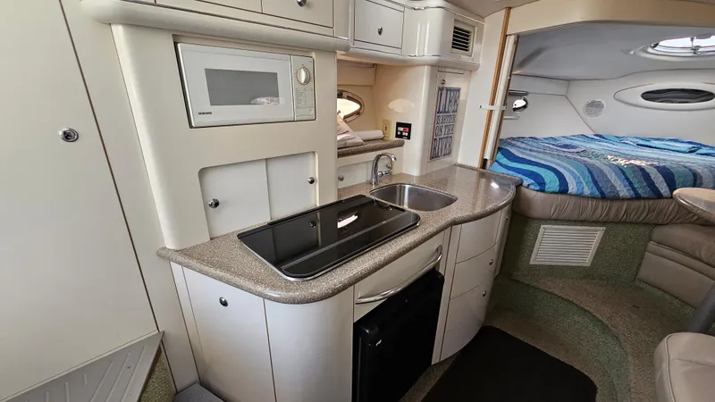 Slide: The Image of 1999 Maxum 3000 SCR boat interior with kitchen and sleeping area. - 21