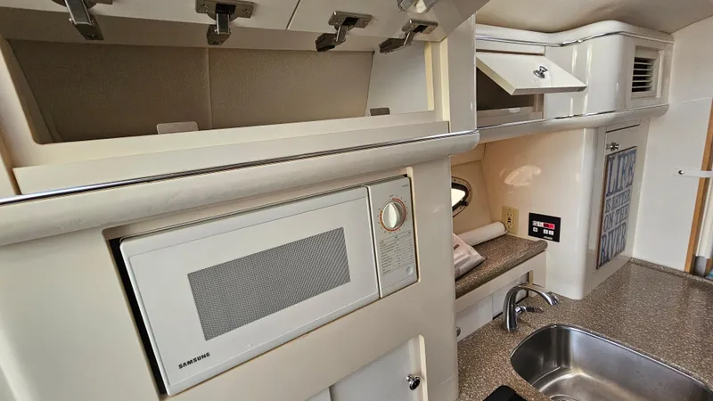 Slide: The Image of Interior of a 1999 Maxum 3000 SCR boat with microwave and sink. - 26
