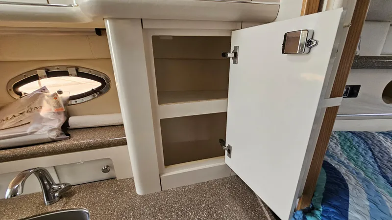Slide: The Image of Open cabinet in the kitchen area of a 1999 Maxum 3000 SCR boat. - 27