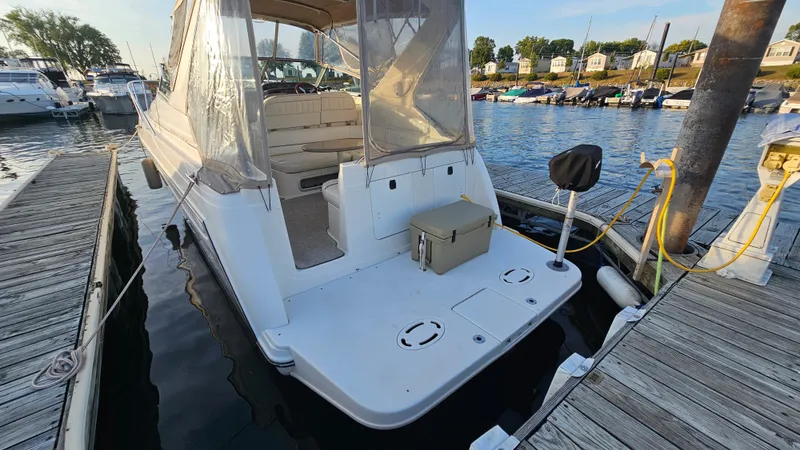 Slide: The Image of 1999 Maxum 3000 SCR boat docked at a marina, rear view. - 6