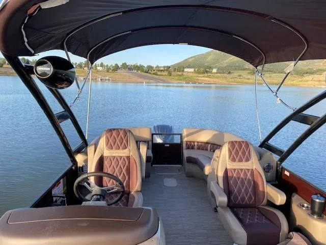 Slide: The Image of 2024 Bennington 24lxsra pontoon boat on a serene lake. - 6