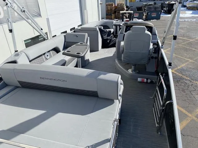 Slide: The Image of 2023 Bennington 25LSB pontoon boat interior with gray seating and helm station. - 5