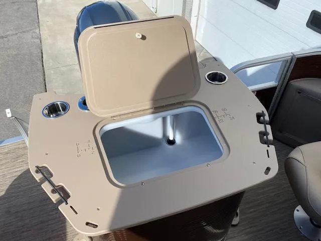 Slide: The Image of 2023 Bennington 22LFAPG boat with open storage compartment and cup holders. - 11