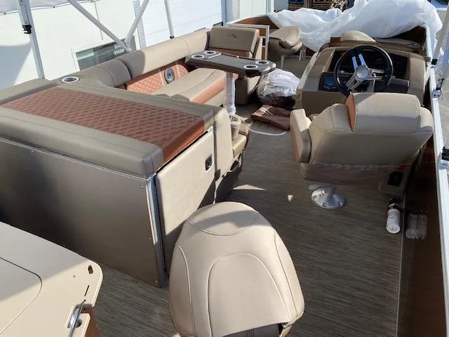 Slide: The Image of 2023 Bennington 22LFAPG pontoon boat interior with beige seating and modern helm. - 4