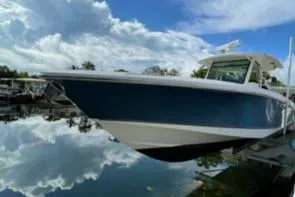 The Image of Boston Whaler 370 Outrage 2012 boat docked on calm water under a cloudy sky. - 0