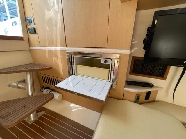 Slide: The Image of Interior of 2012 Boston Whaler 370 Outrage, featuring wooden steps and built-in appliances. - 18