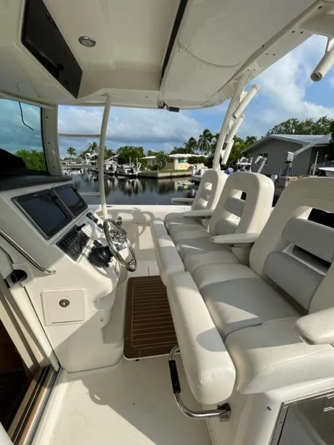 Slide: The Image of 2012 Boston Whaler 370 Outrage boat interior with white seating and modern dashboard. - 4