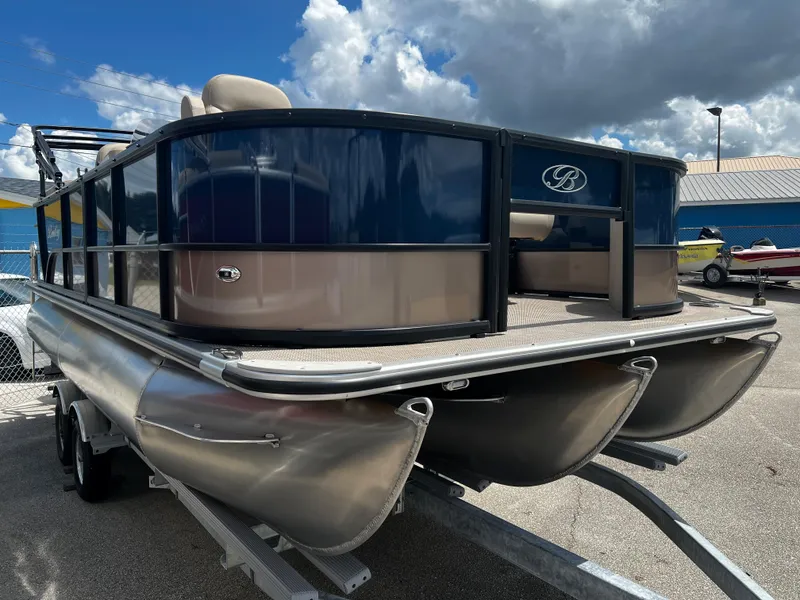 Slide: The Image of 2024 Bentley Pontoons Fish 20 pontoon boat on trailer under a cloudy sky. - 2