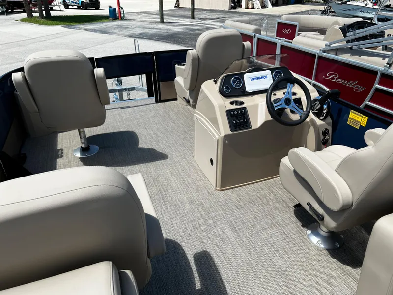 Slide: The Image of 2024 Bentley Pontoons Fish 20 interior with beige seating and steering console. - 9