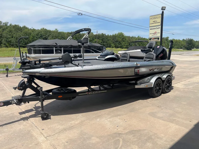 Slide: The Image of 2024 Vexus VX 20 fishing boat on a trailer in a dealership lot. - 2