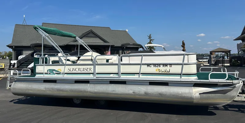 Slide: The Image of 1998 Suncruiser 240 Trinidad pontoon boat parked on a trailer. - 0
