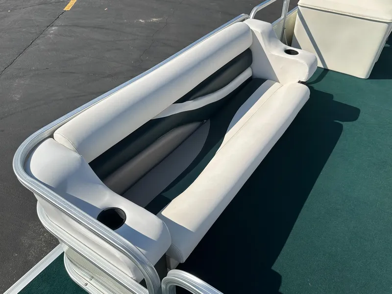 Slide: The Image of 1998 Suncruiser 240 Trinidad boat seating with cup holders on green carpet. - 12