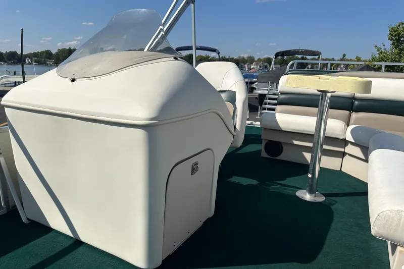 Slide: The Image of 1998 Suncruiser 240 Trinidad boat interior with seating and helm, docked on a sunny day. - 14
