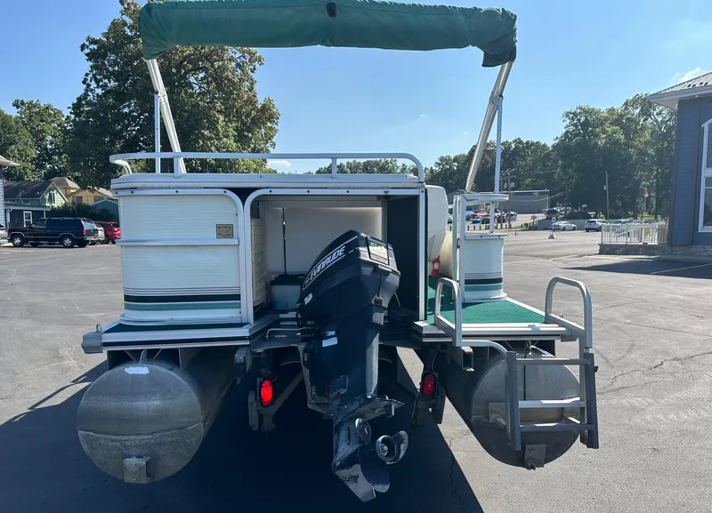 Slide: The Image of 1998 Suncruiser 240 Trinidad pontoon boat with outboard motor, parked outdoors. - 6