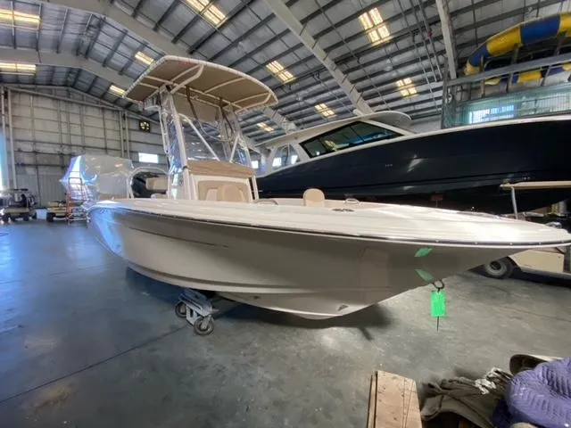 The Image of 2024 Scout 195 Sportfish boat in a spacious indoor showroom. - 0