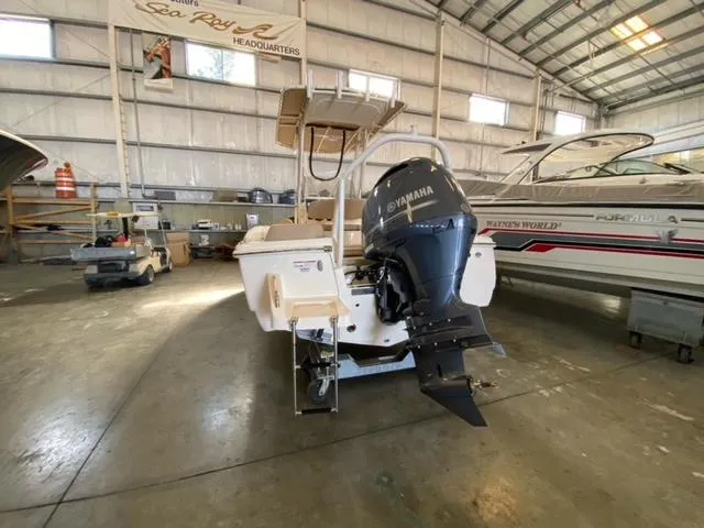 Slide: The Image of 2024 Scout 195 Sportfish boat with Yamaha engine in a spacious indoor showroom. - 2