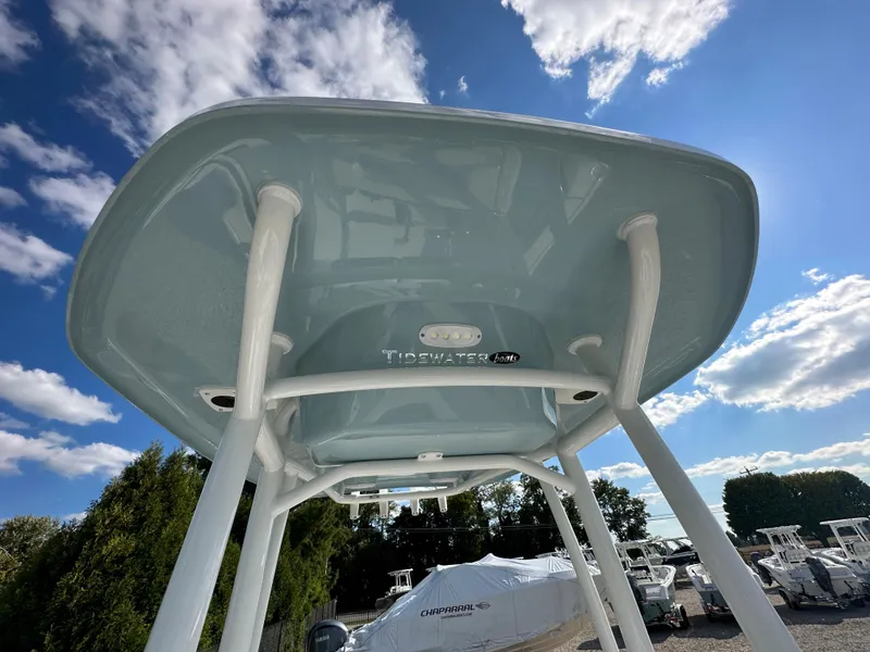 Slide: The Image of 2024 Tidewater 210 CC Adventure boat T-top under a clear blue sky. - 21