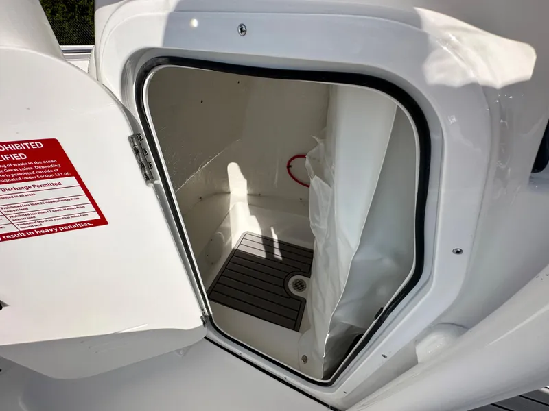 Slide: The Image of 2024 Tidewater 210 CC Adventure boat storage compartment with open door. - 29