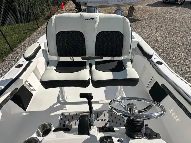 Slide: The Image of 2024 Tidewater 210 CC Adventure boat cockpit with dual seats and steering wheel. - 37
