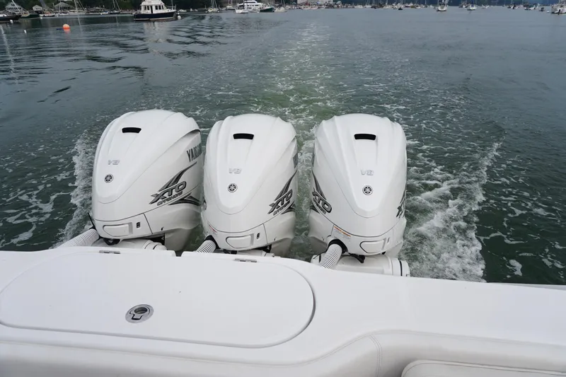 Slide: The Image of Triple Yamaha XTO outboard engines on a 2021 Jupiter 41 SB boat in calm waters. - 9