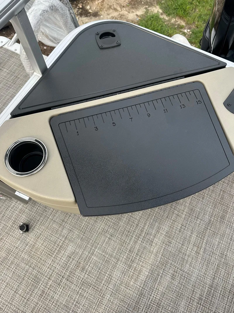 Slide: The Image of 2024 Ranger Reata 200F boat console with measuring board and cup holder. - 12