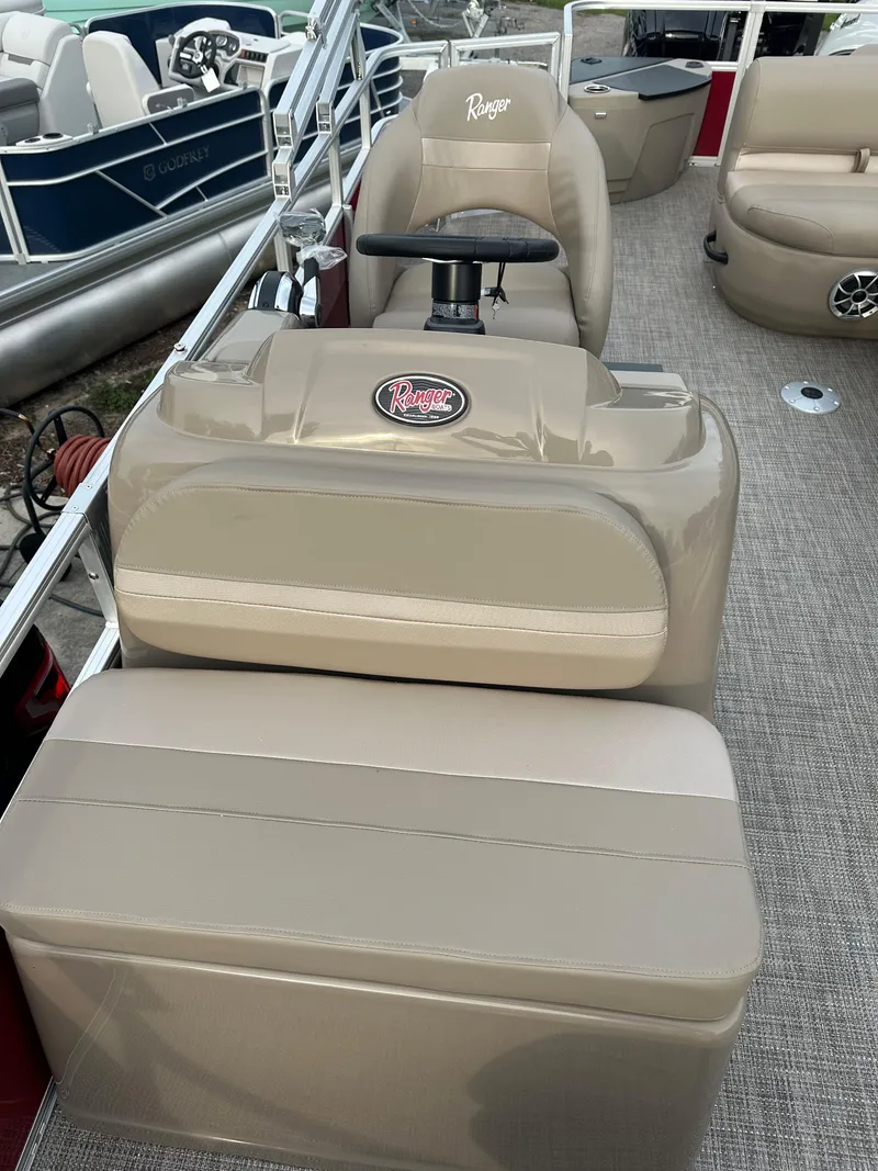 Slide: The Image of 2024 Ranger Reata 200F boat interior with beige seating and steering console. - 8