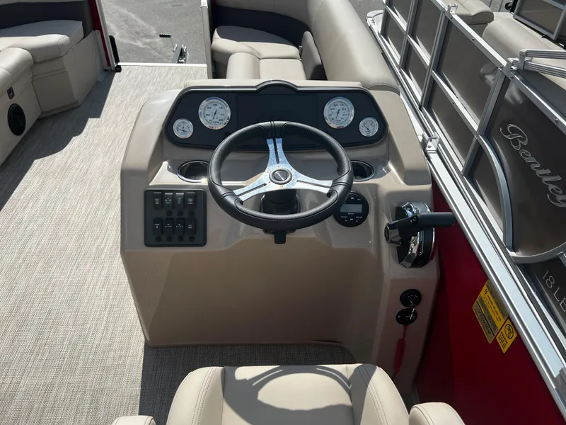 Slide: The Image of 2024 Bentley Pontoons LE 18 boat dashboard with steering wheel and control panel. - 13