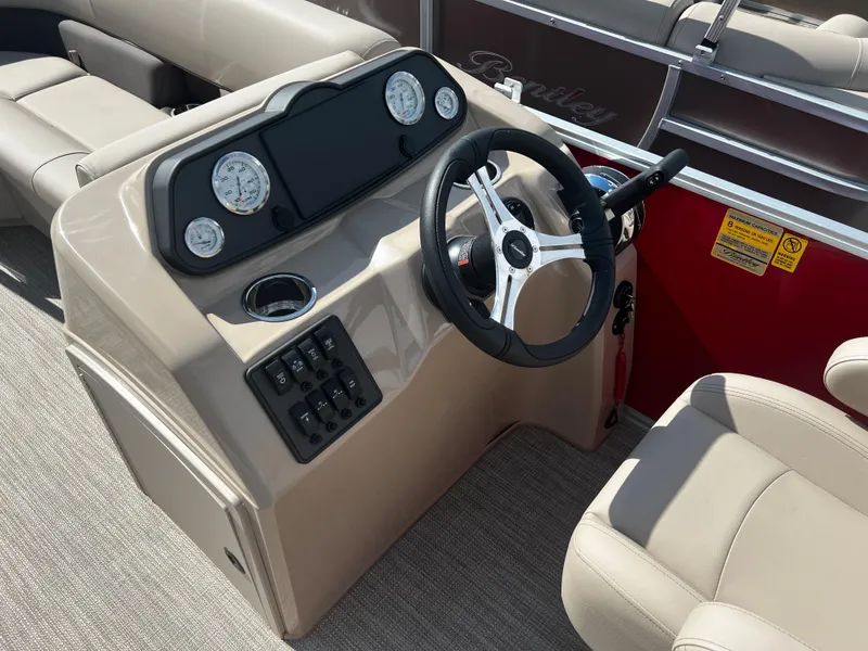 Slide: The Image of 2024 Bentley Pontoons LE 18 boat dashboard with steering wheel and gauges. - 14