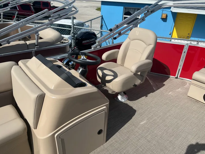 Slide: The Image of 2024 Bentley Pontoons LE 18 boat interior with beige captain's chair and steering console. - 7