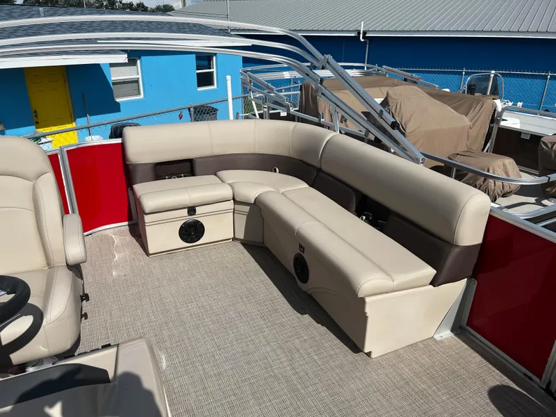 Slide: The Image of 2024 Bentley Pontoons LE 18 interior with beige seating and red accents. - 9