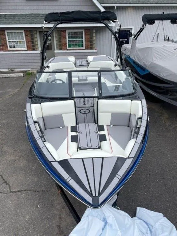 Slide: The Image of 2024 Moomba Craz boat with sleek design and spacious seating, docked outdoors. - 11