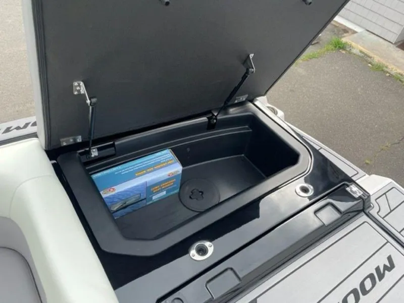 Slide: The Image of 2024 Moomba Craz storage compartment with open lid and packaged item inside. - 14