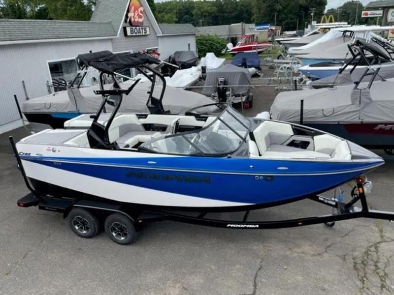 Slide: The Image of 2024 Moomba Craz boat in blue and white, displayed at a dealership. - 4