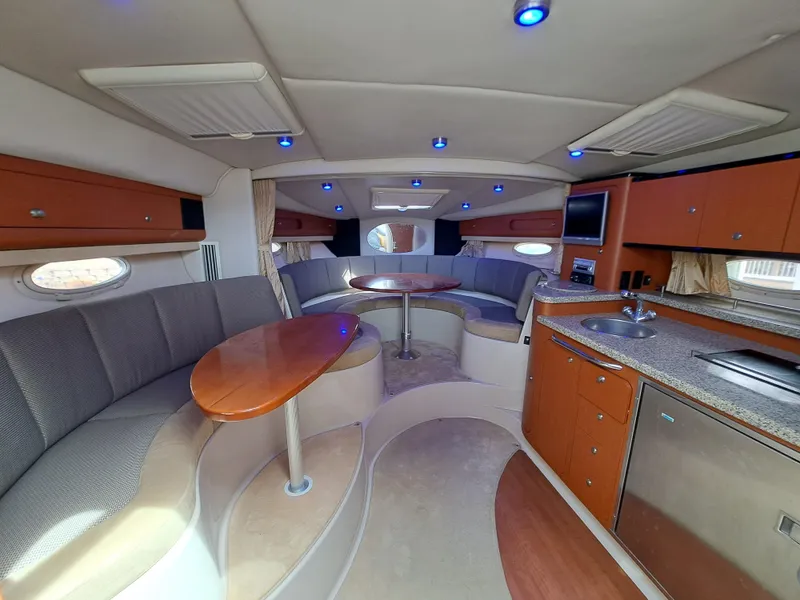 Slide: The Image of Interior of 2005 Chaparral 330 Signature Cruiser with seating, tables, and kitchenette. - 13