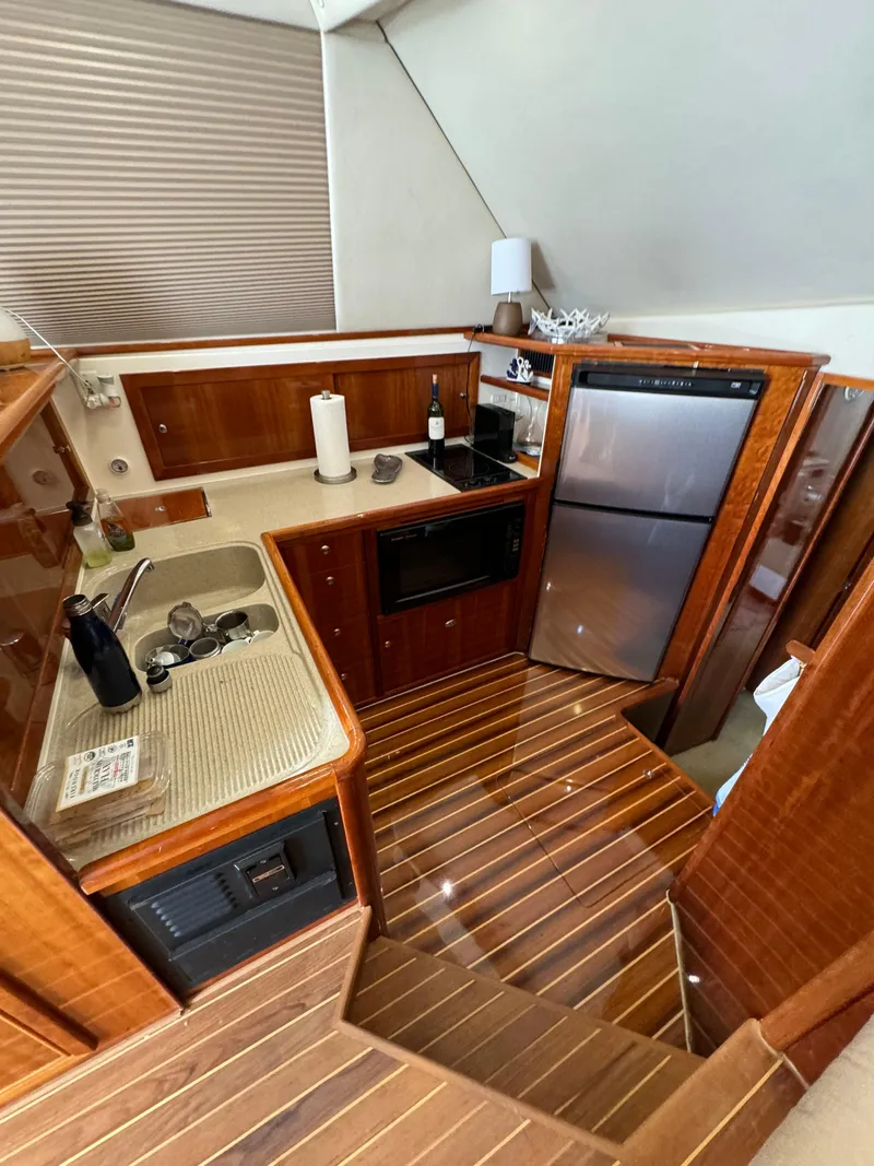 Slide: The Image of Luxurious 2003 Riviera 48 yacht kitchen with wood finish and modern appliances. - 15