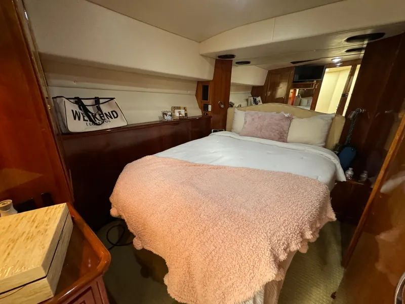 Slide: The Image of Cozy bedroom interior of 2003 Riviera 48 yacht with pink bedding and wooden accents. - 16
