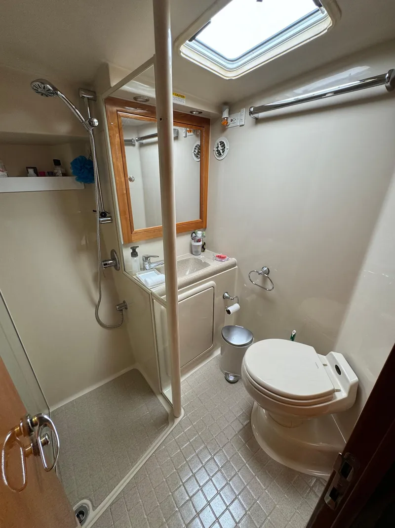 Slide: The Image of 2003 Riviera 48 yacht bathroom with shower, sink, and toilet. - 17