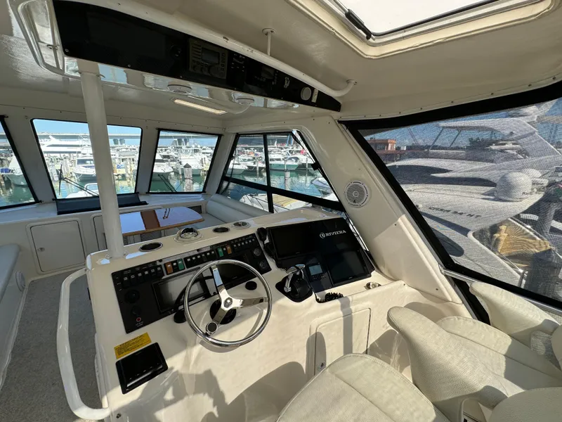 Slide: The Image of Interior of 2003 Riviera 48 yacht cockpit with steering wheel and navigation controls. - 22