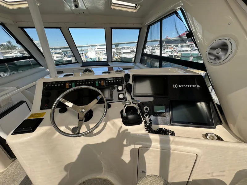 Slide: The Image of 2003 Riviera 48 yacht helm with steering wheel and navigation equipment. - 24