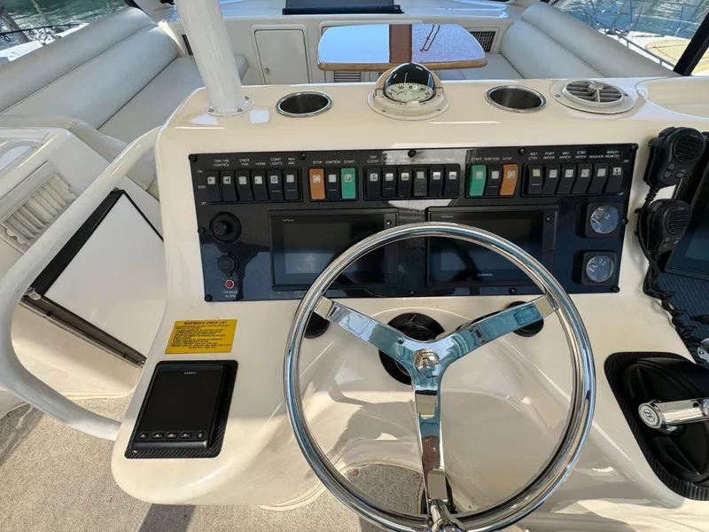 Slide: The Image of Control panel of a 2003 Riviera 48 yacht with steering wheel and navigation instruments. - 25