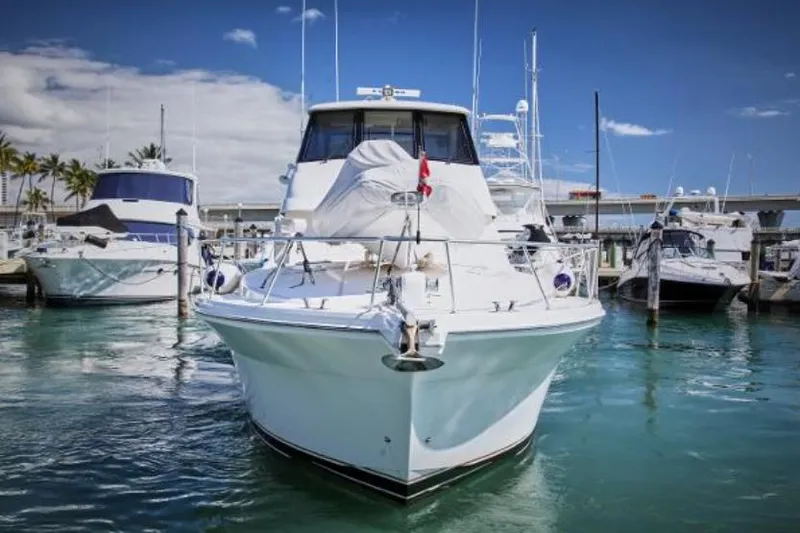 Slide: The Image of 2003 Riviera 48 yacht docked in a marina on a sunny day. - 6
