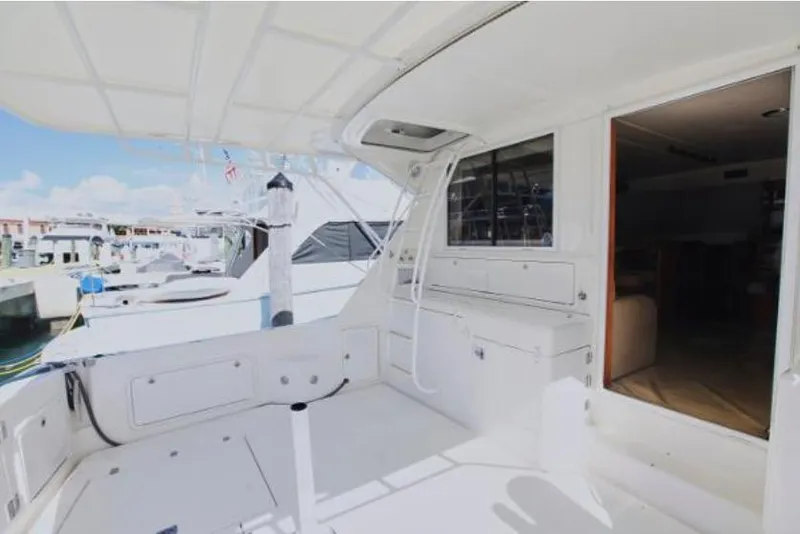 Slide: The Image of 2003 Riviera 48 yacht docked at marina, spacious deck area. - 7