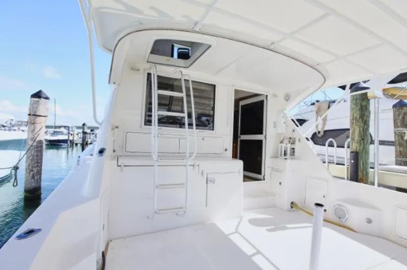 Slide: The Image of 2003 Riviera 48 yacht stern view with ladder and marina background. - 8