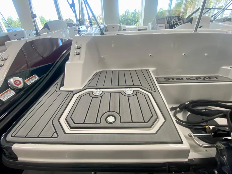 Slide: The Image of 2024 Starcraft SVX 191 boat deck with non-slip surface and storage compartments. - 5