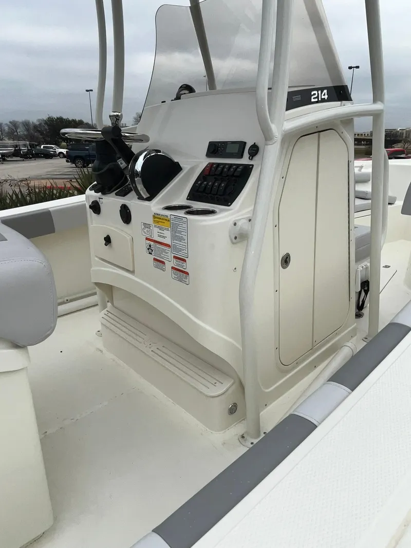 Slide: The Image of 2024 Mako 214 CC center console boat with steering wheel and control panel. - 5