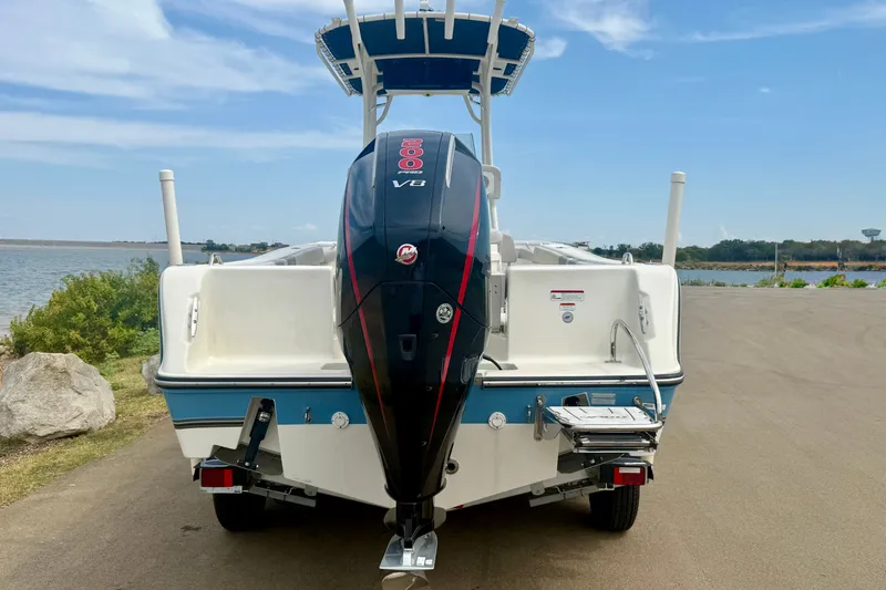 Slide: The Image of 2024 Mako 214 Center Console boat with powerful V8 engine, parked near a scenic waterfront. - 6